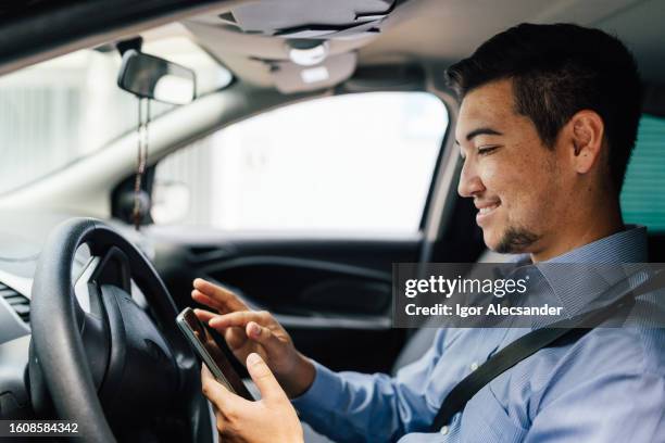 taxi driver checking requests on smartphone - taxi driver stock pictures, royalty-free photos & images