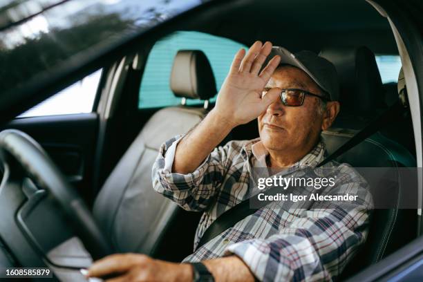 elderly driver waving in car - travel real people stockfoto's en -beelden