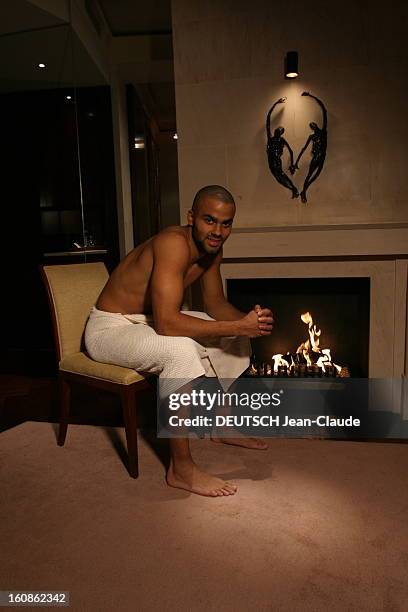 Rendezvous With Tony Parker In Paris. Attitude souriante de Tony PARKER torse nu, une serviette ceinte autour des hanches, assis devant un feu de...