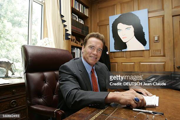 Rendezvous With Arnold Schwarzenegger. Plan de face souriant d'Arnold SCHWARZENEGGER, en costume d'homme d'affaires, assis à son bureau de gouverneur...