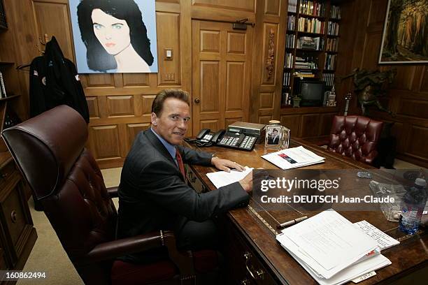 Rendezvous With Arnold Schwarzenegger. Attitude souriante d'Arnold SCHWARZENEGGER, en costume d'homme d'affaires, travaillant à son bureau de...