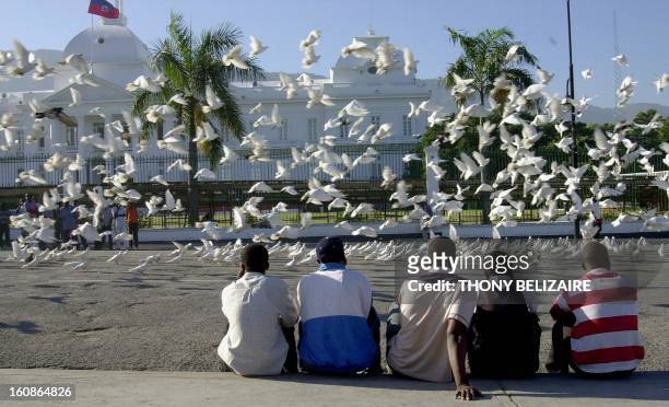 Haitian men watch a flock of birds in front of the presidential palace in Port-Au-Prince. Haiti is preparing to celebrate the 200th year of...