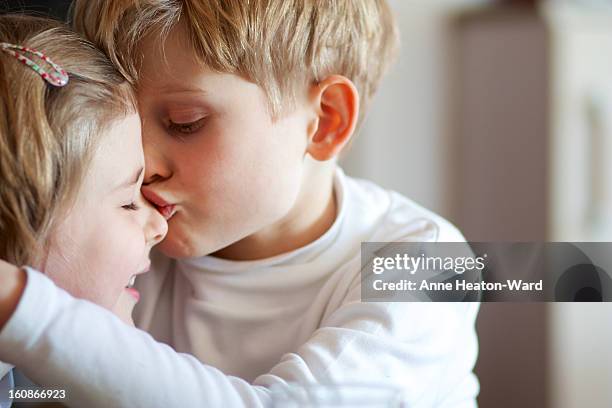 big brother gives his sister a kiss - kiss sisters stock pictures, royalty-free photos & images