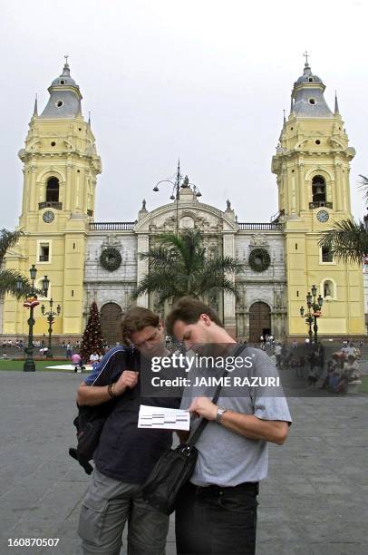 Two tourists read a guide book in the Plaza Mayor in Lima, Peru, 03 January 2001. The president of the National Commission of Tourism indicated 02...