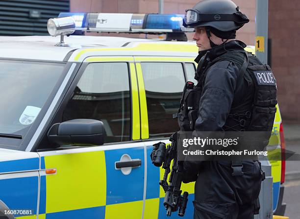 Armed police stand guard as Dale Cregan and nine other co-defendants arrive in an armed convoy to face charges of murder and attempted murder at...