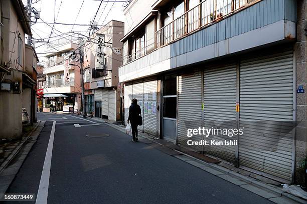 Woman walks at a almost shuttered shopping street near Shinjuku area on February 7, 2013 in Tokyo, Japan. A recent servey shows Tokyo as the most...