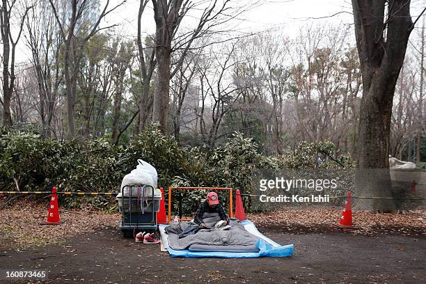 Homeless, staying at Shunjuku Central Park reads a manga on February 7, 2013 in Tokyo, Japan. A recent servey shows Tokyo as the most expensive city...