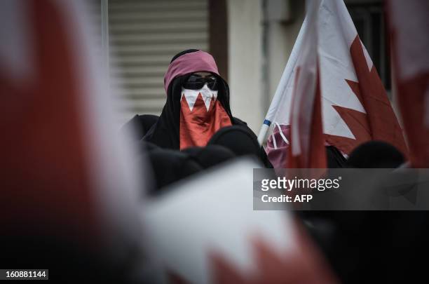 Bahraini woman covers her face with a national flag during an anti-government rally to demand reforms on February 7, 2013 in the village of Karannah,...