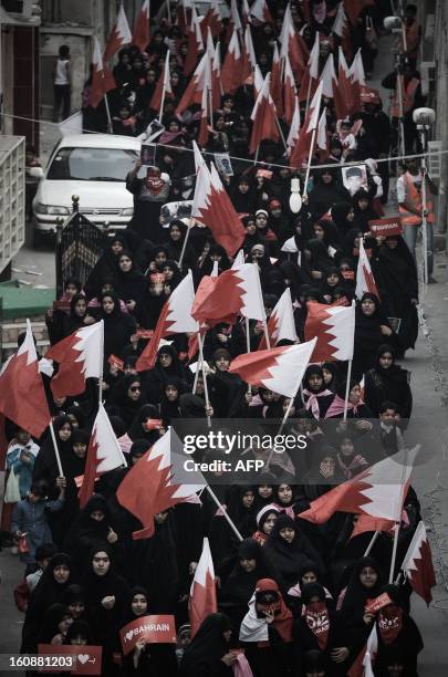 Bahraini women hold up national flags during an anti-government rally to demand reforms on February 7, 2013 in the village of Karannah, west of the...