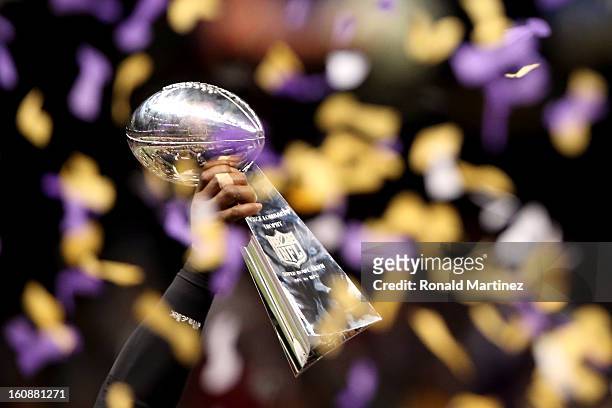 Detail of the Vince Lombardi Championship trophy held up by a player from the Baltimore Ravens as confetti falls after the Ravens won 34-31 against...