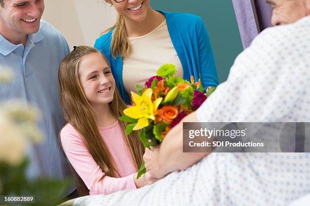 junges mädchen mit eltern auf besuch großvater im krankenhaus - visit stock-fotos und bilder