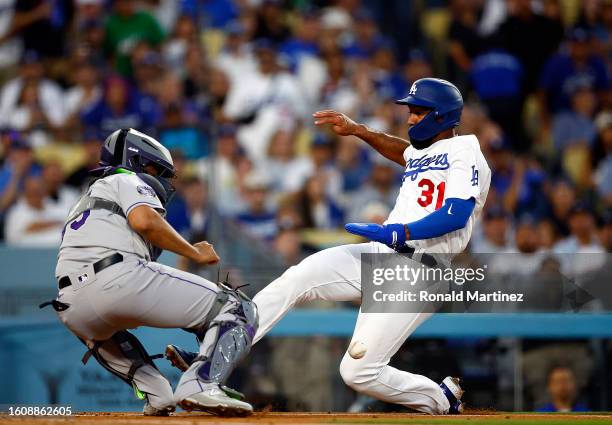 Elias Diaz of the Colorado Rockies makes the out against Amed Rosario of the Los Angeles Dodgers in the second inning at Dodger Stadium on August 11,...