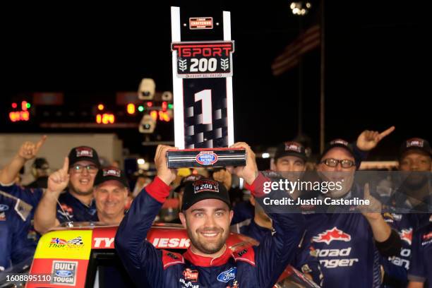 Ty Majeski, driver of the Road Ranger Ford, lifts the TSport 200 trophy in victory lane after winning the NASCAR Craftsman Truck Series TSport 200 at...