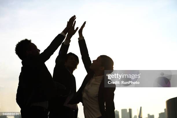 business people at twilight - business high five stock pictures, royalty-free photos & images