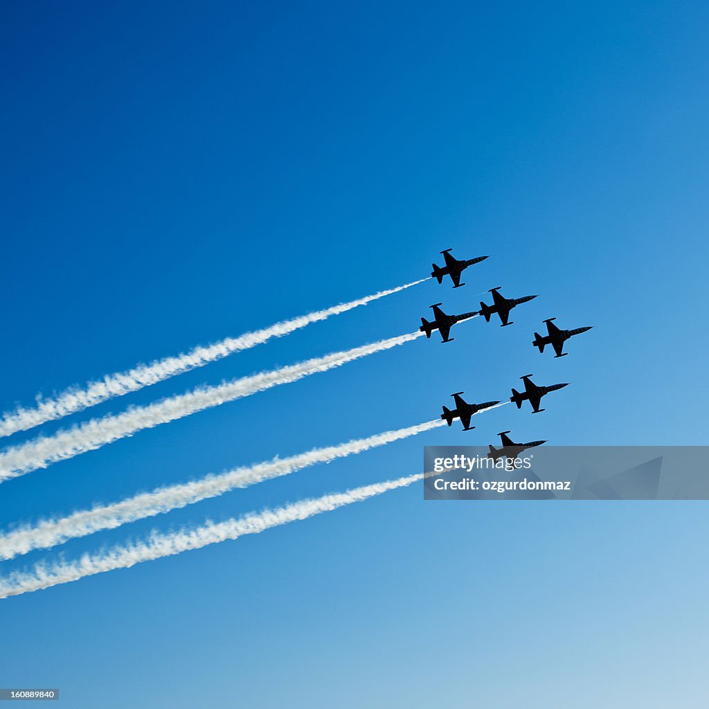 Fighter planes in airshow on blue sky