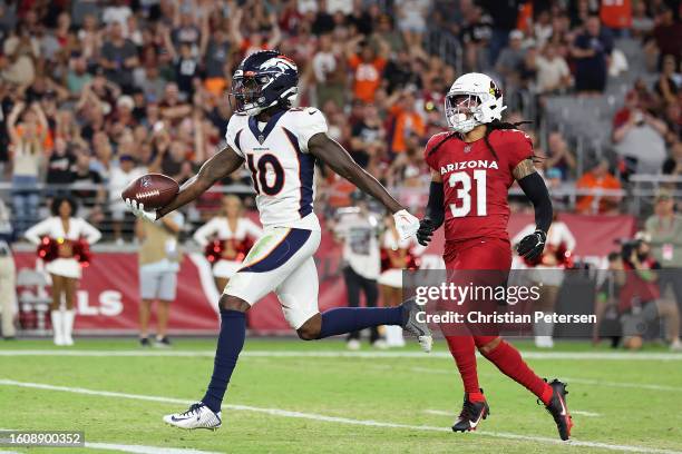 Wide receiver Jerry Jeudy of the Denver Broncos scores a 21-yard touchdown reception ahead of safety Andre Chachere of the Arizona Cardinals during...