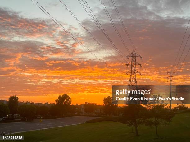 powerful transmission tower illuminated against a dramatic sunset tower illuminated against a dramatic sunset - evan kissner stock pictures, royalty-free photos & images