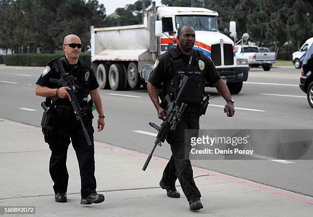 San Diego Harbor Police officers walk outside of Naval Base Point Loma as police search for suspect, former LAPD officer Christopher Jordan Dorner,...