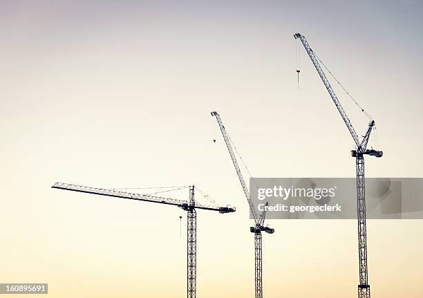 construction cranes at dawn - construction site and silhouette stock pictures, royalty-free photos & images
