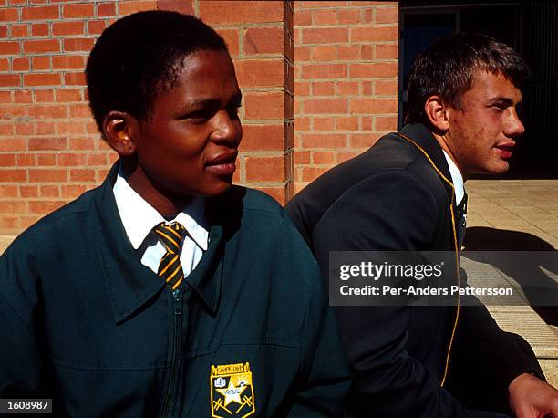 Black student and a white student sit on the campus June 21, 2001 of Vryburg High School in Vryburg, South Africa. Vryburg, a small and very...