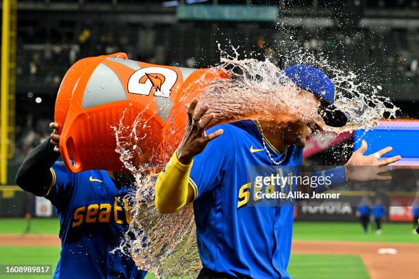 Teoscar Hernandez of the Seattle Mariners gives Julio Rodriguez a Gatorade bath after the game against the Baltimore Orioles at T-Mobile Park on...