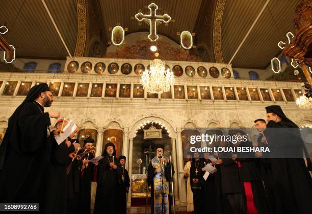 Syrian Christian priests carry candles as they attend prayers for the Palestinians killed in Gaza lead by Christian Orthodox Patriarch of Antioch and...