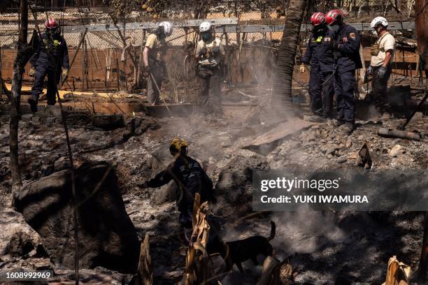 Search and recovery team members check charred buildings and cars in the aftermath of the Maui wildfires in Lahaina, Hawaii, on August 18, 2023. At...