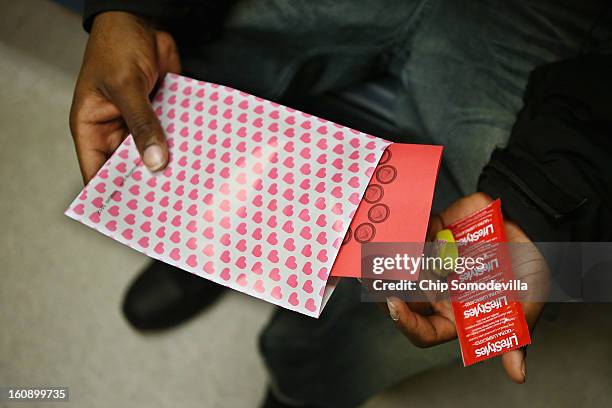 Visitors to the Whitman-Walker Health mobile testing vehicle hold gift packs that include Valentine's Day candies, prophylactics and informational...