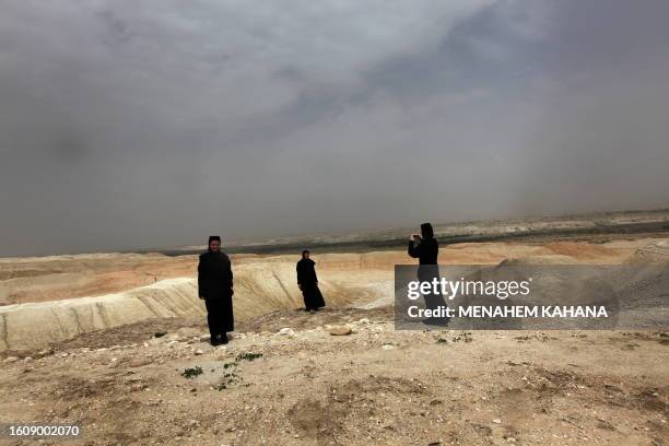 Christian Orthodox nun takes a picture with the view of the Jordan valley desert at the Qasr al-Yahud baptismal site on April 14, 2009. Thousands of...