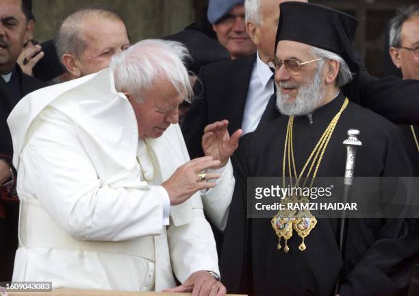 Pope John Paul II and Greek Orthodox Patriarch Ignatius IV Hazim greet each other in front of the gutted St. George church in Quneitra 07 May 2001....
