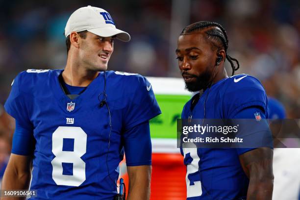 Quarterbacks Daniel Jones and Tyrod Taylor of the New York Giants talk on the bench during a pre-season football game against the Carolina Panthers...