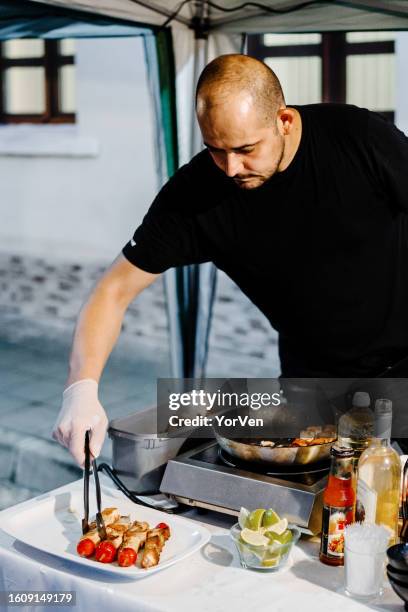 chef professionista che prepara spiedini di salmone alla festa all'aperto - red hot summer party foto e immagini stock