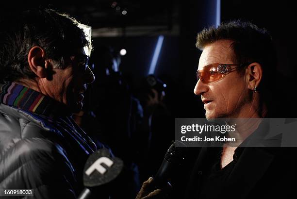 Edun co-founder Bono speaks to the media backstage at the Edun Fall 2013 fashion show during Mercedes-Benz Fashion Week at Skylight West on February...