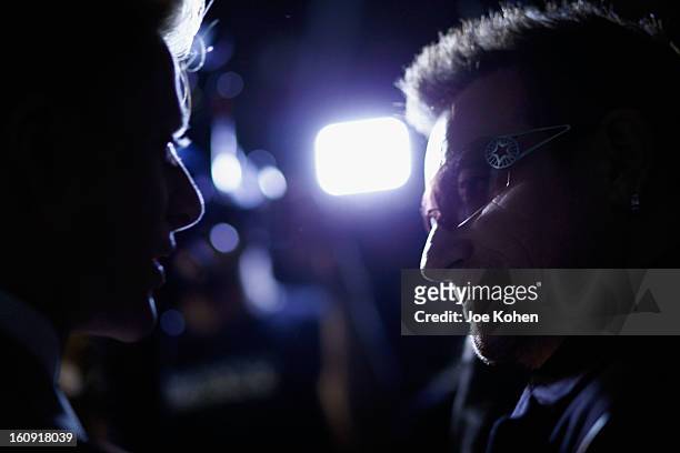 Edun co-founder Bono speaks to the media backstage at the Edun Fall 2013 fashion show during Mercedes-Benz Fashion Week at Skylight West on February...