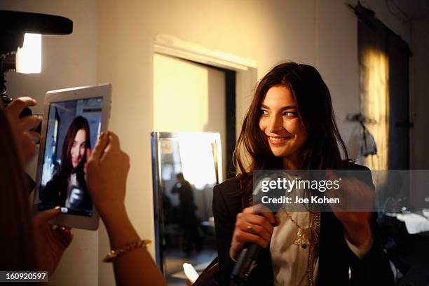 Model prepares backstage at the Edun Fall 2013 fashion show during Mercedes-Benz Fashion Week at Skylight West on February 7, 2013 in New York City.