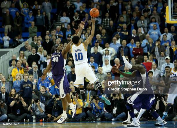 Larry Drew II of the UCLA Bruins makes the winning basket as time runs out in the game against Sean Kemp, Jr.#40 and Aziz N'diaye of the Washington...