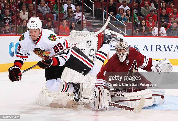 Goaltender Jason LaBarbera of the Phoenix Coyotes follows the action as Bryan Bickell of the Chicago Blackhawks is tripped up during the third period...