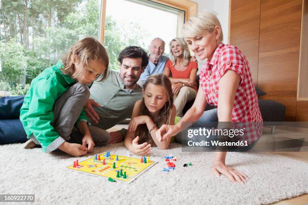 germany, bavaria, nuremberg, family playing board game together - brettspiel stock-fotos und bilder