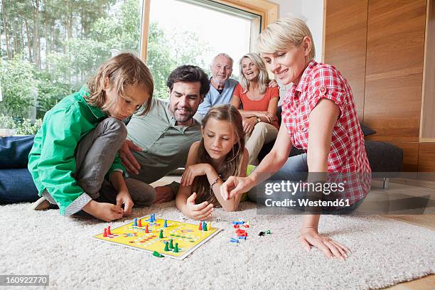 germany, bavaria, nuremberg, family playing board game together - board game stock pictures, royalty-free photos & images