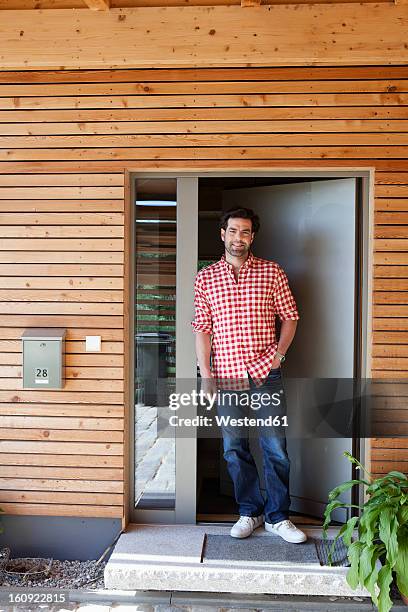 germany, bavaria, nuremberg, mature man standing at front door of house - bavarian man in front of house stock-fotos und bilder