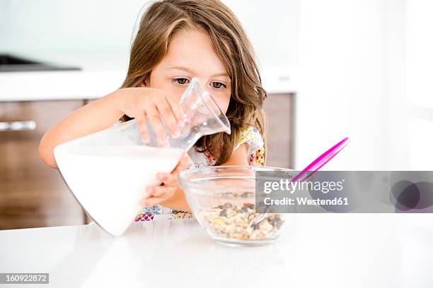 germany, girl pouring milk in muesli - 注ぐ ストックフォトと画像