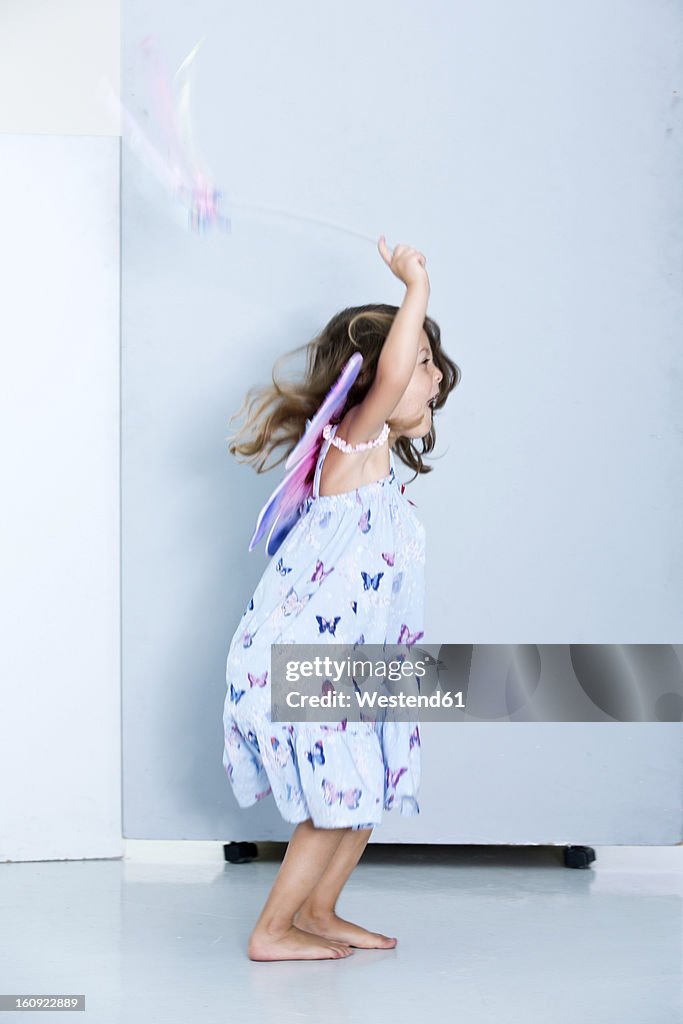 Germany, Girl playing with wings