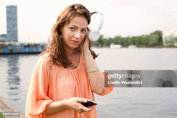 germany, berlin, young woman listening music at treptower park - treptower park stock pictures, royalty-free photos & images