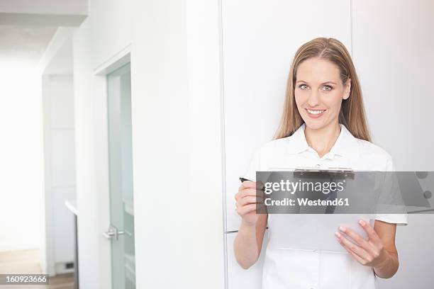 germany, dentist holding clip board - sprechstundenhilfe stock-fotos und bilder