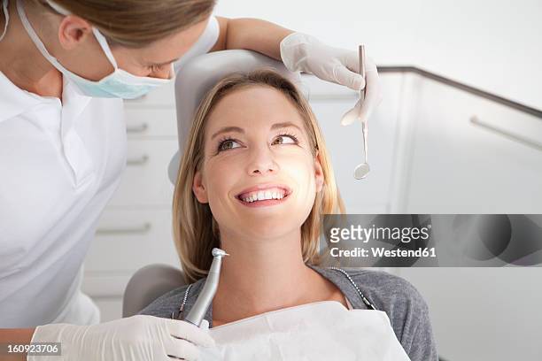 germany, young woman getting her teeth examined by dentist - dental care stock-fotos und bilder