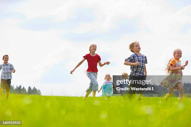 germany, bavaria, group of children running through meadow - memmingen stock pictures, royalty-free photos & images