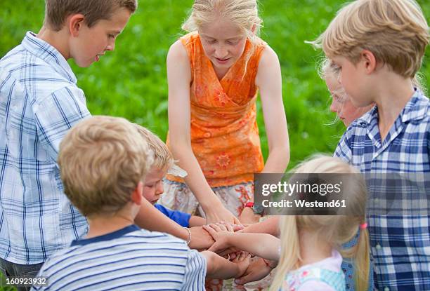 germany, bavaria, group of children putting hands together - memmingen stock pictures, royalty-free photos & images