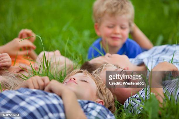 germanny, bavaria, group of children lying in meadow - memmingen stock pictures, royalty-free photos & images