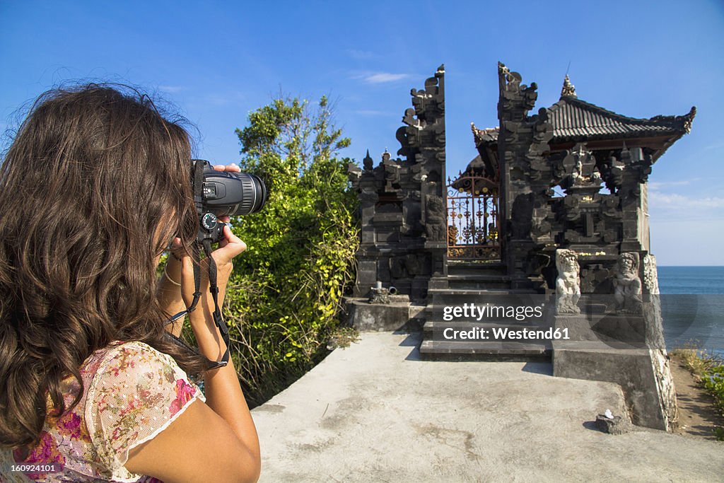 Indonesia, Tourist taking photograph of Batu Bolong Temple