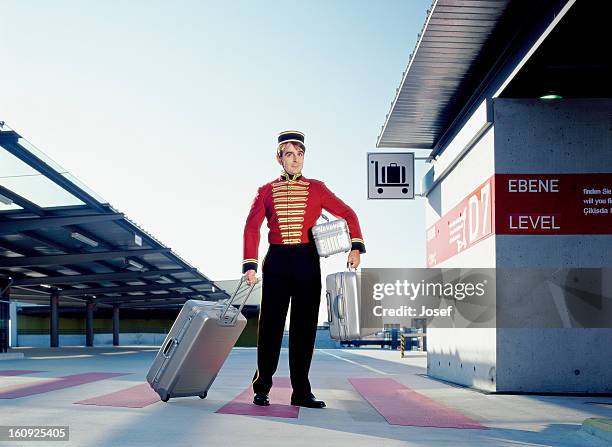 portrait of bellboy carrying suitcases - bell boy stock pictures, royalty-free photos & images